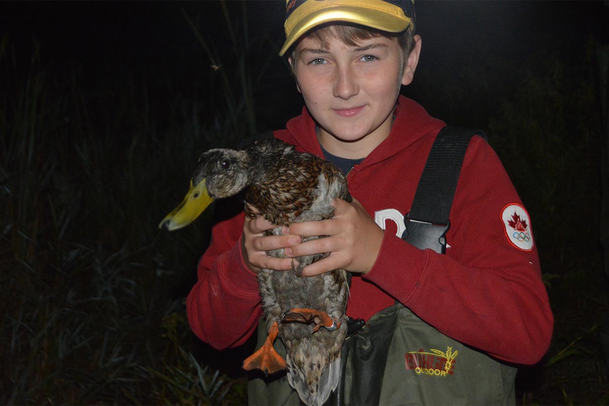 Students holding up a duck